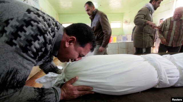 A man sobs over the shrouded body of his son, who was killed by a car-bomb attack, before his burial at a cemetery in Najaf, south of Baghdad, on January 31.