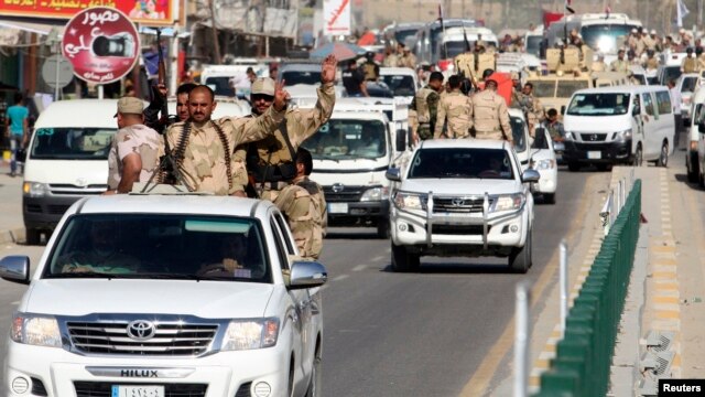 Shi'ite volunteers who have joined the Iraqi Army to fight against the predominantly Sunni militants from the radical Islamic State of Iraq and the Levant parade down a street in Karbala, southwest of Baghdad, on June 26.