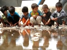Iraq - Iraqi displaced children gathered around pool of water at their refugee camp in Al-Najaf, 31May2007