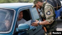 A Ukrainian serviceman checks documents at a checkpoint near Slovyansk in the Donetsk region.