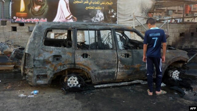 A boy inspects a burn-out vehicle the day after a bomb attack near a funeral tent in the Sadr City district of Baghdad, which killed several people on September 21. There have been three deadly attacks on funerals in as many days in Iraq.