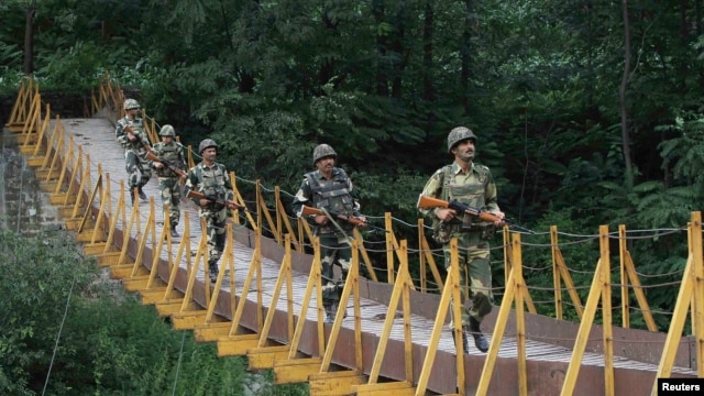 Indian Border Security Force (BSF) soldiers patrol a footbridge built over a stream near the Line of Control (LoC), a cease-fire line dividing Kashmir between India and Pakistan, in August.