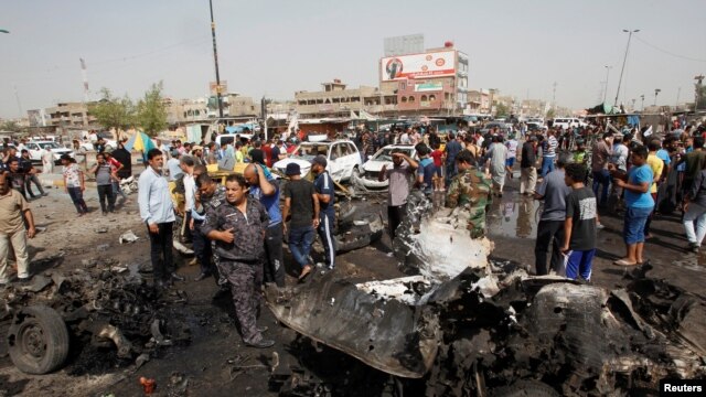 Iraqi security forces and onlookers gather at the site of a car bomb attack in Baghdad's mainly Shi'ite district of Sadr City on May 17.