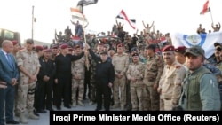 Iraqi Prime Minister Haidar al-Abadi holds an Iraqi flag as he declares victory over IS in Mosul on July 10.