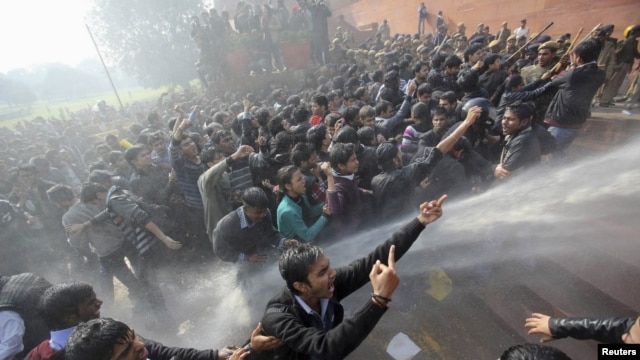 Demonstrators shout slogans as police use water cannons to disperse them near the presidential palace during a protest rally in New Delhi on December 22, following the gang rape of a woman on a municipal bus.