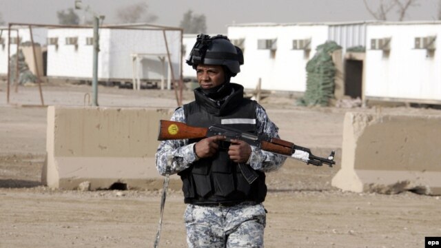 An Iraqi soldier stands guard at a former U.S military base that has housed the Iranian opposition group Mujahedin-e Khalq Organization refugees near Baghdad.