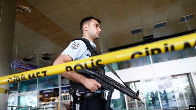 An armed Turkish policeman patrols behind a police line following the attack at Ataturk international airport in Istanbul on June 29.