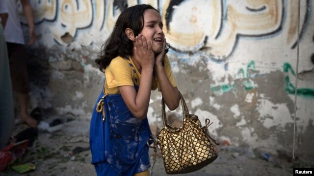 A Palestinian girl reacts at the scene of an explosion that medics said killed eight children and two adults, and wounded 40 others at a public garden in Gaza City on July 28.