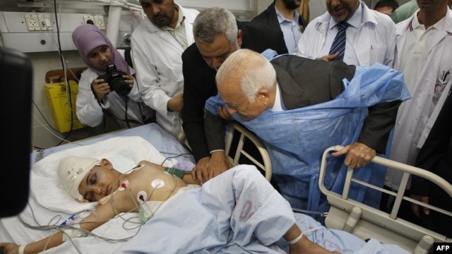 Arab League Secretary-General Nabil Elaraby (center right) and senior Hamas leader Ismail Haniyah (third from left) visit a boy who Palestinian medics say was wounded in an Israeli air strike at a hospital in Gaza City.