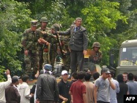 Kyrgyz soldiers stand on an armored vehicle in the streets of Osh on June 11.