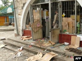 A man looks at a vandalized building on the streets of Osh.