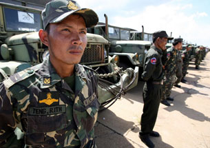 Cambodian soldiers stand in front of military trucks donated by the U.S. Army in Phnom Penh, June 2, 2008.