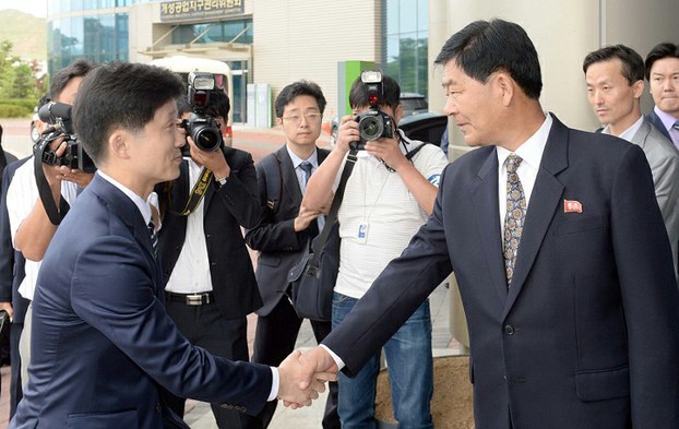 South Korea's chief delegate Lee Sang-Min (L), a senior Unification Ministry official, shakes hands with his North Korean counterpart Pak Chol-Su (R) before wage talks in Kaesong, North Korea, July 16, 2015.