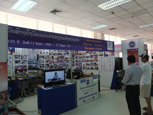 Attendees view an exhibition booth during an event to mark the 65th anniversary of Lao Media and Publication Day in Vientiane, Aug. 13, 2015