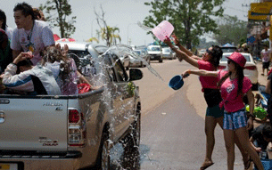 Laotian girls throw buckets of water on colleagues during the water festival celebrations in Vientiane, April 13, 2012.
