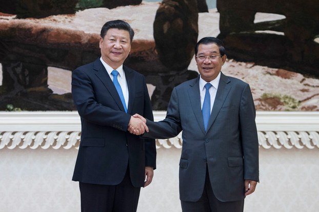 Chinese President Xi Jinping (L) shakes hands with Cambodian Prime Minister Hun Sen in Phnom Penh, Oct. 13, 2016.