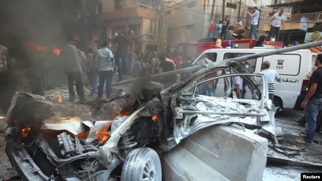 A destroyed car is seen at the site of an explosion in Beirut's southern suburbs on August 15.