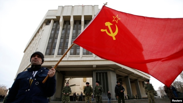 A man holds a Soviet flag as he attends a pro-Russian rally at the Crimean parliament building in Simferopol on March 6.
