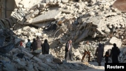 People walk past the rubble of damaged buildings in a rebel-held area of Aleppo on November 6.