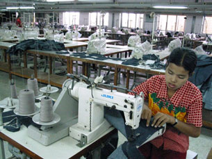 A woman works on her sewing machine at a garment factory in Rangoon, Dec. 1, 2003.