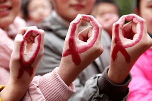 Chinese students show their hands painted to look like red ribbons during a World AIDS Day event in Hanshan, central China's Anhui province, Nov. 30, 2012.