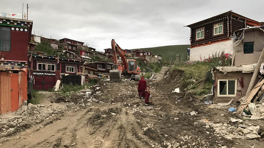 An excavator sits atop a recently razed residential area of Yachen Gar in Sichuan's Kardze prefecture, Aug. 11, 2017.