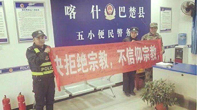 Police display an anti-religion propaganda banner in Kashgar's Maralbeshi county, February 2018. .