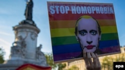 A demonstrator holds a placard depicting Russian President Vladimir Putin with the label 'Stop Homophobia' to denounce the antigay campaign launched in the Russian region of Chechnya during a protest held in Paris on April 20.