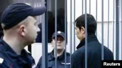 Abror Azimov, a suspect in the recent bombing in St. Petersburg, stands inside the defendant's cage at a Moscow court hearing.