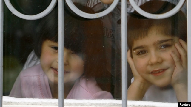 Children look out a window at an orphanage in the southern city of Rostov-na-Donu.