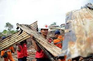 Red Cross rescue workers clear debris from destroyed houses following days of ethnic violence in Sittwe, the Rakhine state capital, June 16, 2012.
