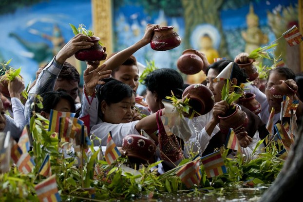 Buddhist devotees pour water on a sacred tree as they take part in a ceremony at the Shwedagon pagoda to mark Buddha's birthday in Yangon, May 13, 2014.