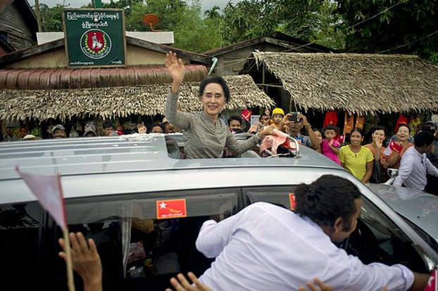 Aung San Suu Kyi waves to supporters as she leaves an election campaign rally in Kawhmu township outside Yangon in central Myanmar, Sept. 21, 2015.
