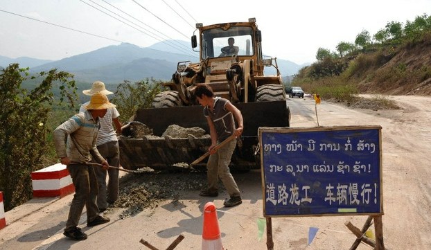 Chinese workers repair a road leading to the special economic zone in the border zone of Boten in northern Laos's Luang Namtha province on March 11, 2011.