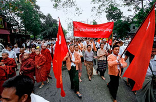 RANGOON, Burma: National League for Democracy (NLD) members carrying flags join Buddhist monks marching in protest, 24 September 2007 AFP