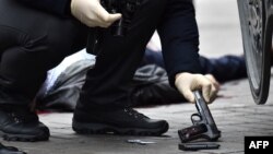 A Ukrainian police expert retrieves a gun at the scene where Denis Voronenkov was shot dead in the center of Kyiv on March 23.