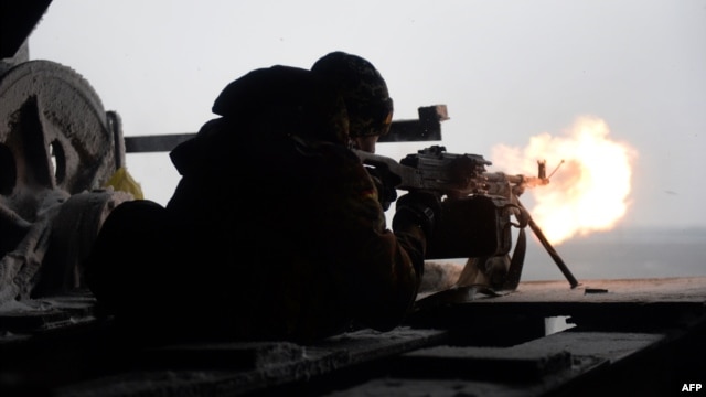 A Ukrainian Right Sector batallion volunteer fires a machine gun from his position near the eastern Ukrainian village of Pisky, in the Donetsk region, on January 3.