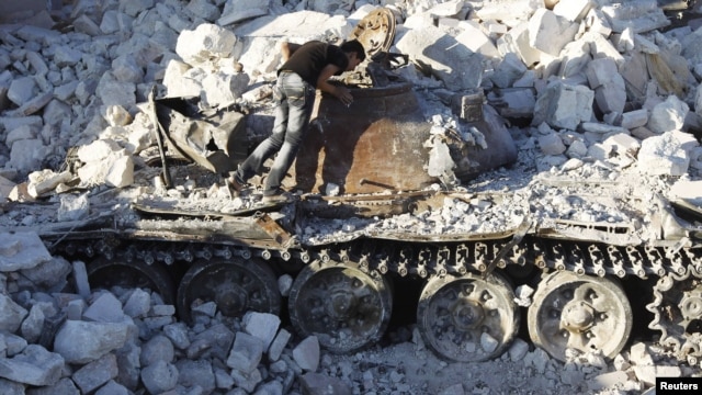 A man inspects a destroyed Syrian Army tank in Azaz, some 47 kilometers north of Aleppo.