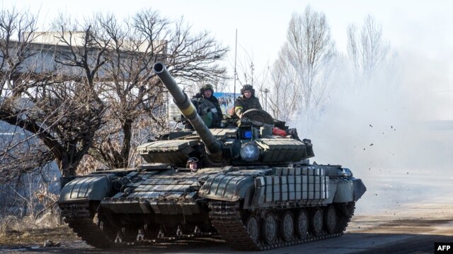 A Ukrainian tank drives on a road not far from the eastern Ukrainian city of Debaltseve on February 13, 2015. 