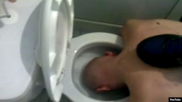 The first video shows a purported inmate at the facility naked and being forced to dunk his head in toilets, which his tormentors proceed to flush.