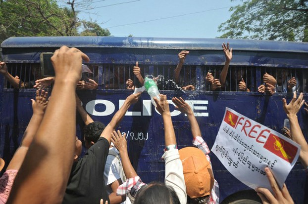 Student protesters and activists gesture from a departing police truck following a court hearing in Letpadan in central Myanmar, April 7, 2015.