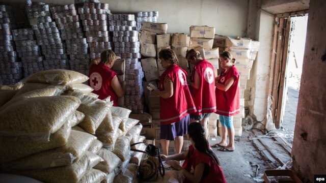 International Committee of the Red Cross workers enter a storehouse to check products after a Ukrainian convoy delivered humanitarian aid for eastern Ukrainian regions, in the town of Starobilsk, in August 2014.