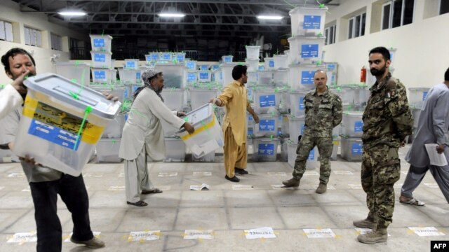 Afghan election-commission workers move ballot boxes to a truck for delivery to Kabul for an audit of the presidential runoff votes in the western Herat Province last month.