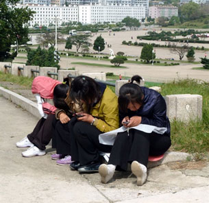 North Korean girls use mobile phones in a park in Pyongyang, Sept. 22, 2010.