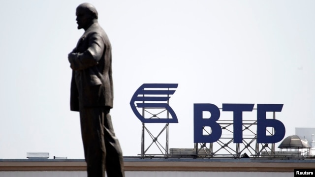 A sign for VTB Bank atop a building is seen beyond a monument of Soviet state founder Vladimir Lenin in central Stavropol, in southern Russia.
