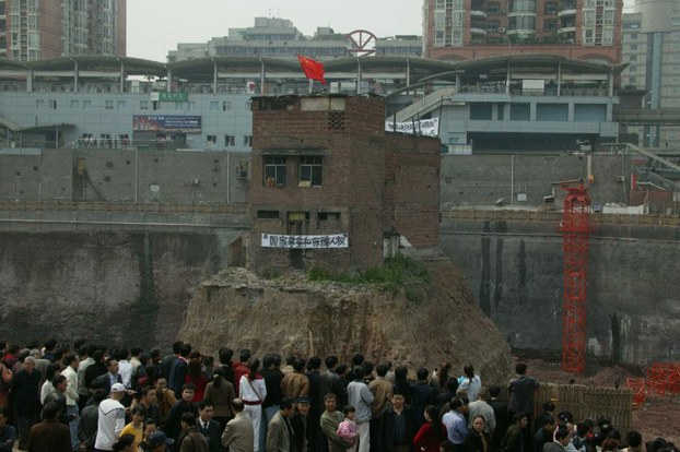 Supporters surround the house of a man facing forced eviction, a common cause of strife in China, in Chongqing, March 24, 2007.