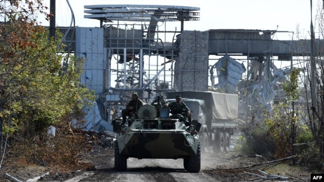 Pro-Russian armored vehicles drive down a road leading to the destroyed Luhansk International Airport, in eastern Ukraine, on September 11.
