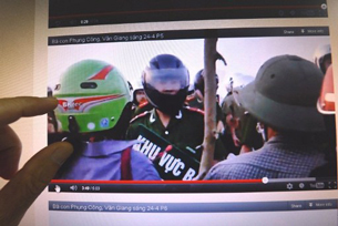 A Vietnamese man watches a blog video showing villagers challenging policemen during forced land evictions, May 7, 2012.