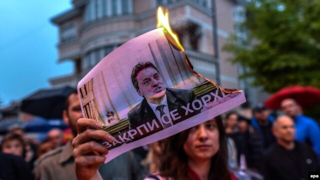 A protestor burns a picture of Macedonia's former Prime Minister Nikola Gruevski.  The Balkan country has been in political turmoil since February 2015 over a wiretapping scandal.