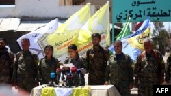 Commanders of the U.S.-backed Syrian Democratic Forces (SDF) speak during a press conference in the Syrian town of Tabqa on May 11.